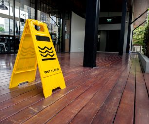 yellow plastic cone with sign showing warning of wet floor in restaurant